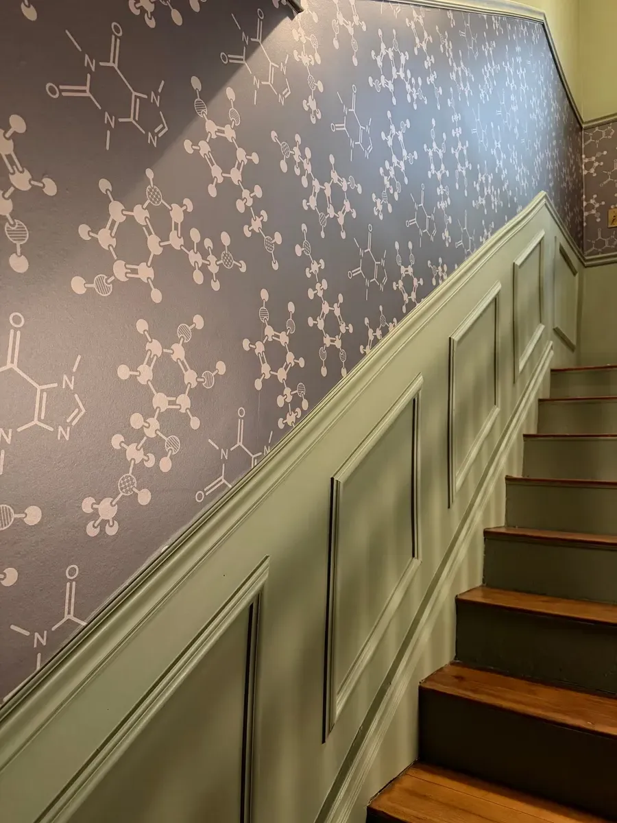 Staircase lined with molecular-pattern wallpaper inside the Good Gene practice